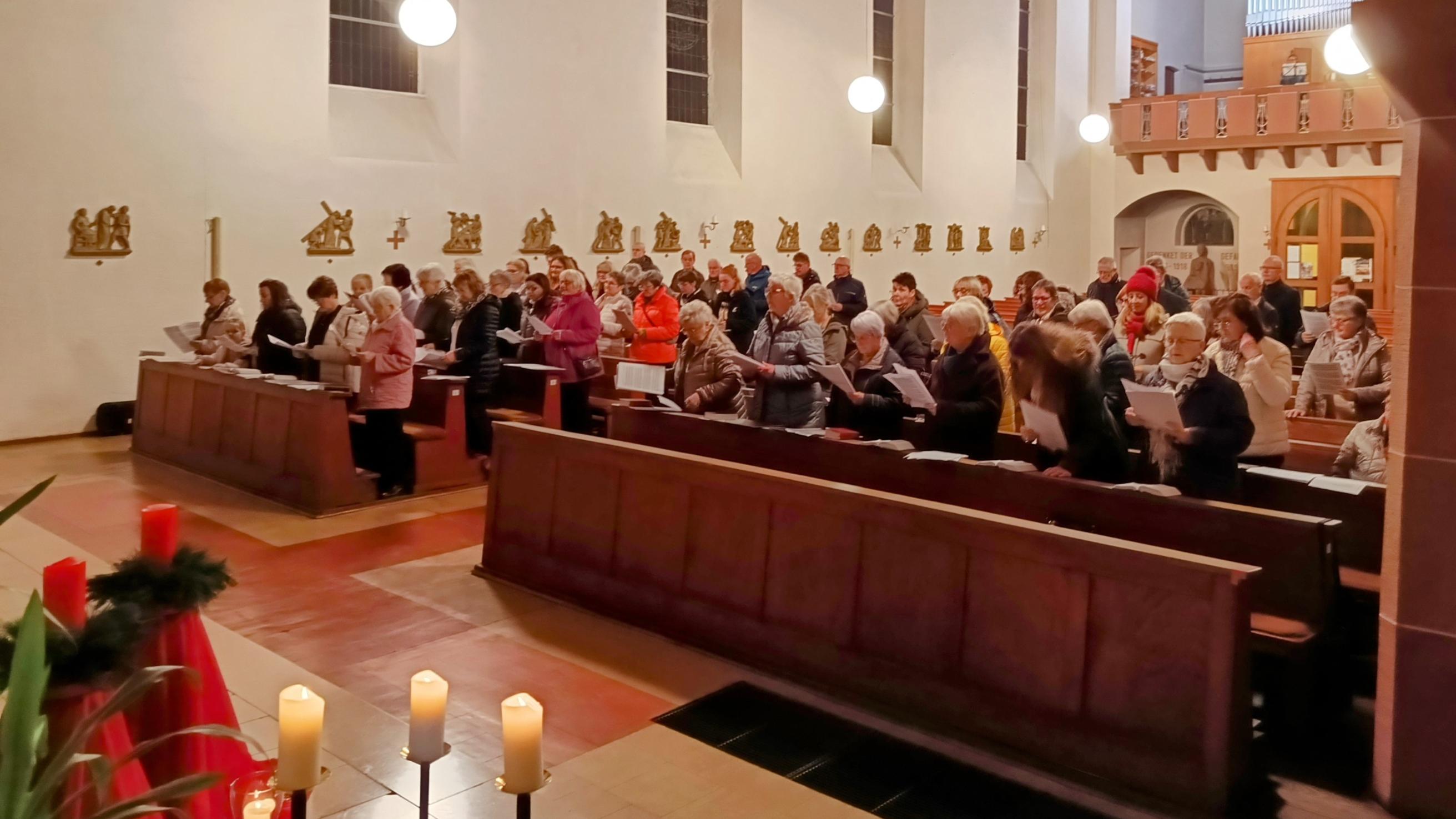 Man sieht eine Kirche mit singenden Menschen