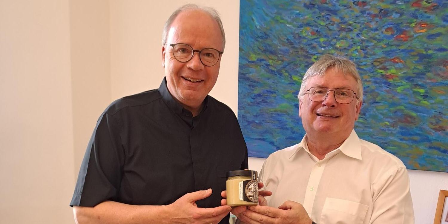 Herr Dekan Leist überreicht Herrn Bischof Ackermann ein Glas Honig